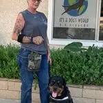Trainer standing with a dog outside It's A Dog's World K-9 Academy